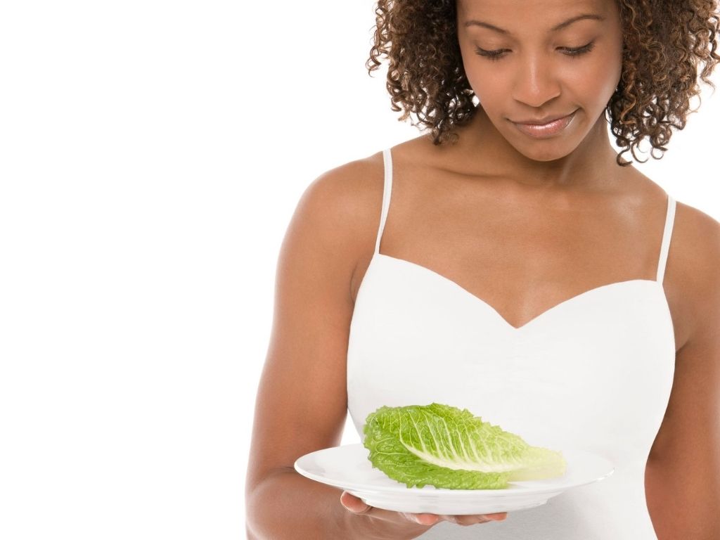 Woman looking at a plate of lettuce