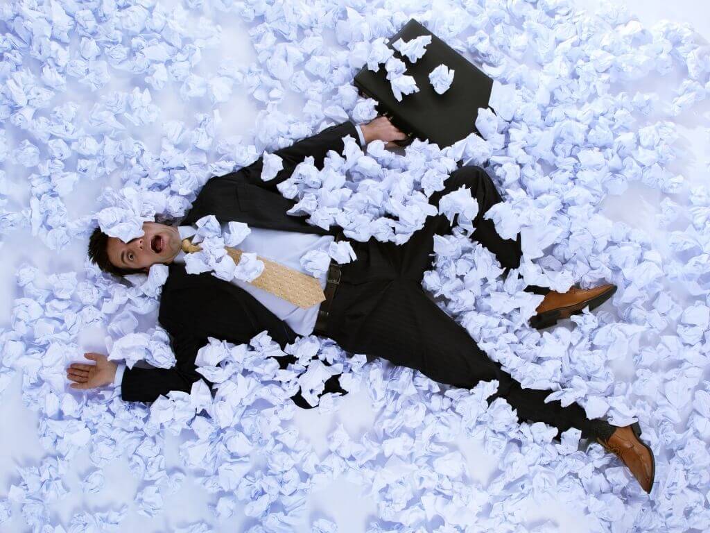 Man in Business Suit laying on ground stressed and overwhelmed